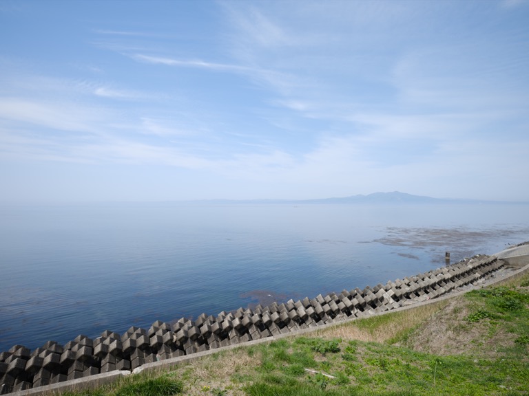 Mutsu Bay beyond tetrapods, with the Shimokita Peninsula faint in the haze on a clear day.